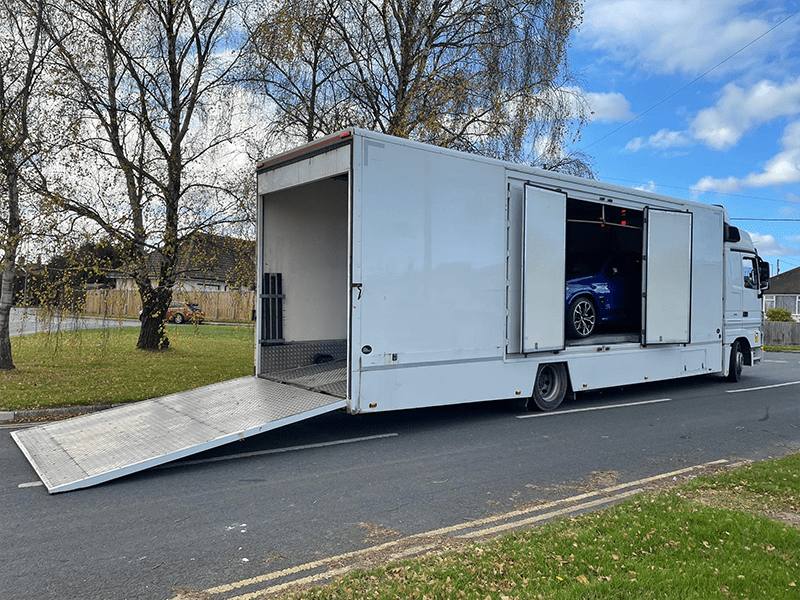 A single vehicle being transported on its own trailer